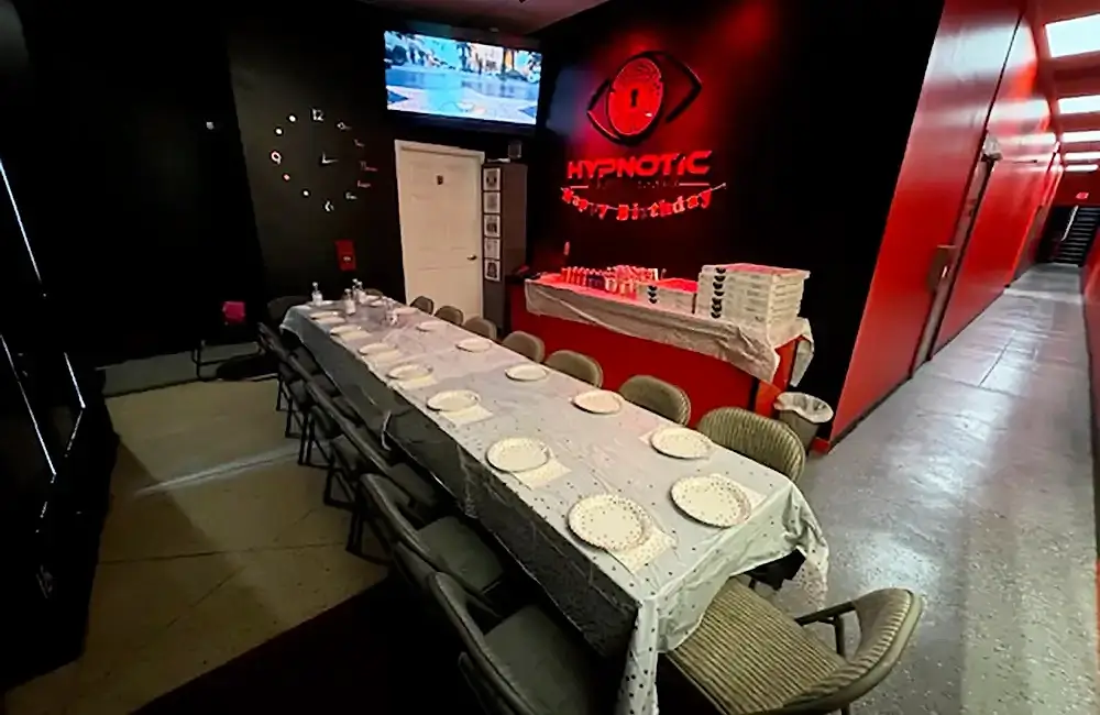 The lobby table laid with place settings for a private party, the screen wall behind it