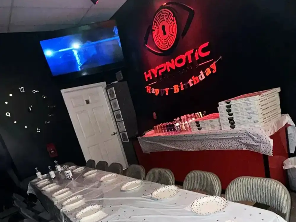 The lobby table set for a birthday group, pizza boxes stacked at the far end