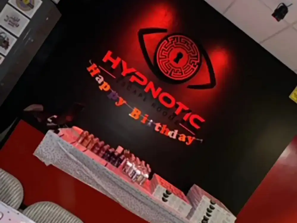 Place settings on the lobby table beneath the lit 'Happy Birthday' wall