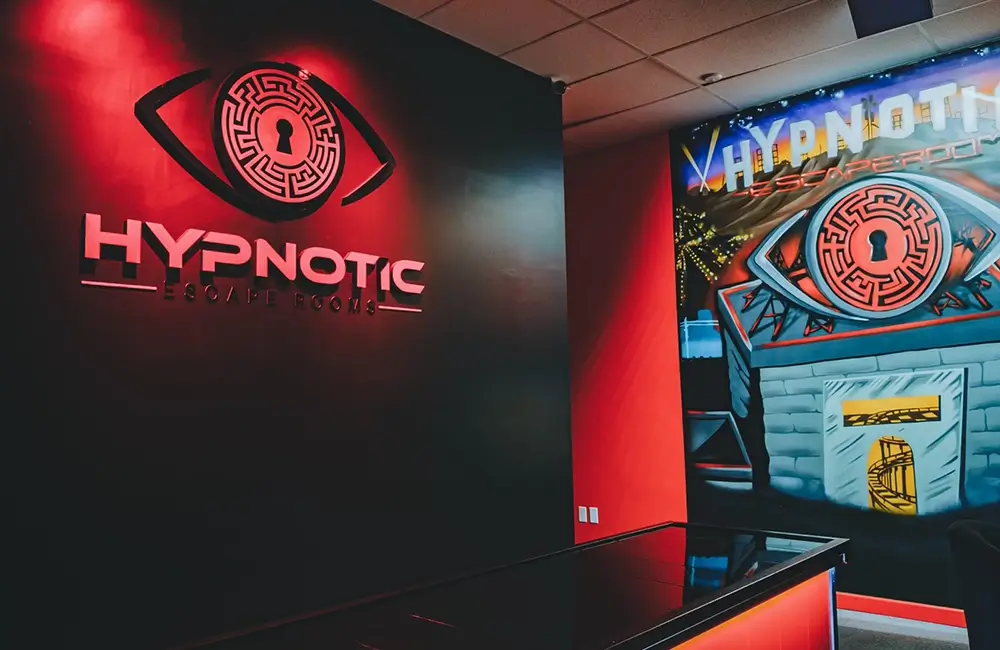 The lit logo wall and mural at the entrance to the lobby