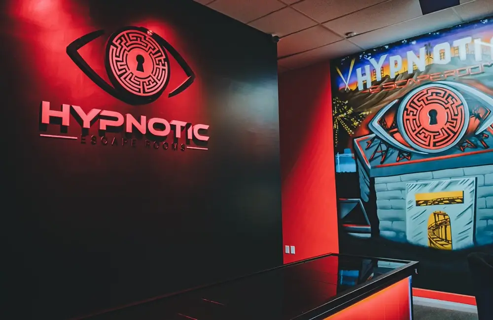 The Hypnotic logo wall lit red, with the lobby's arcade mural alongside it