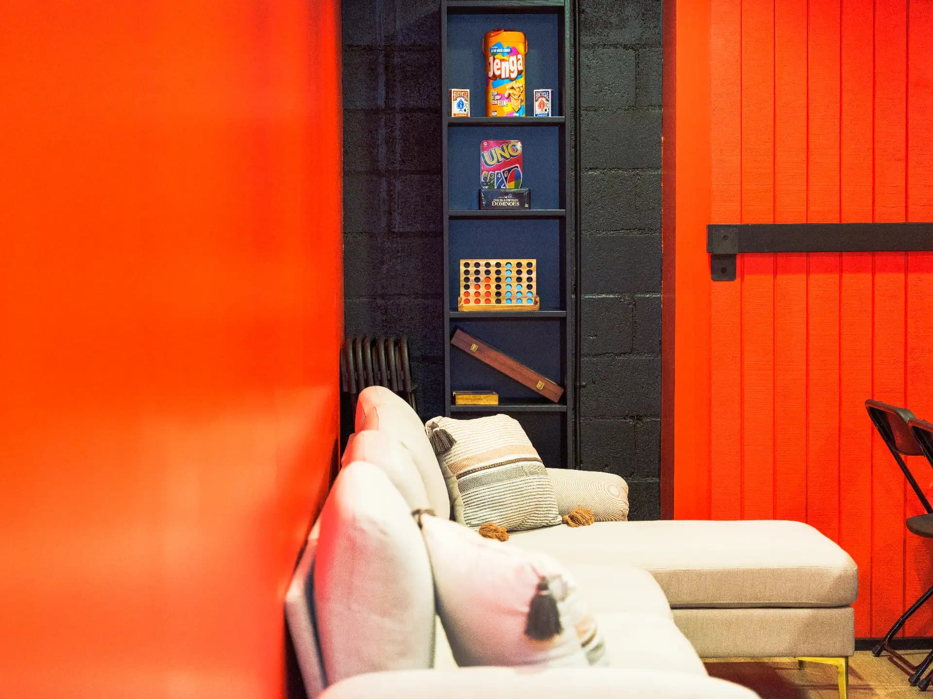 The games shelf and lounge sofa tucked into the red corner of the party room