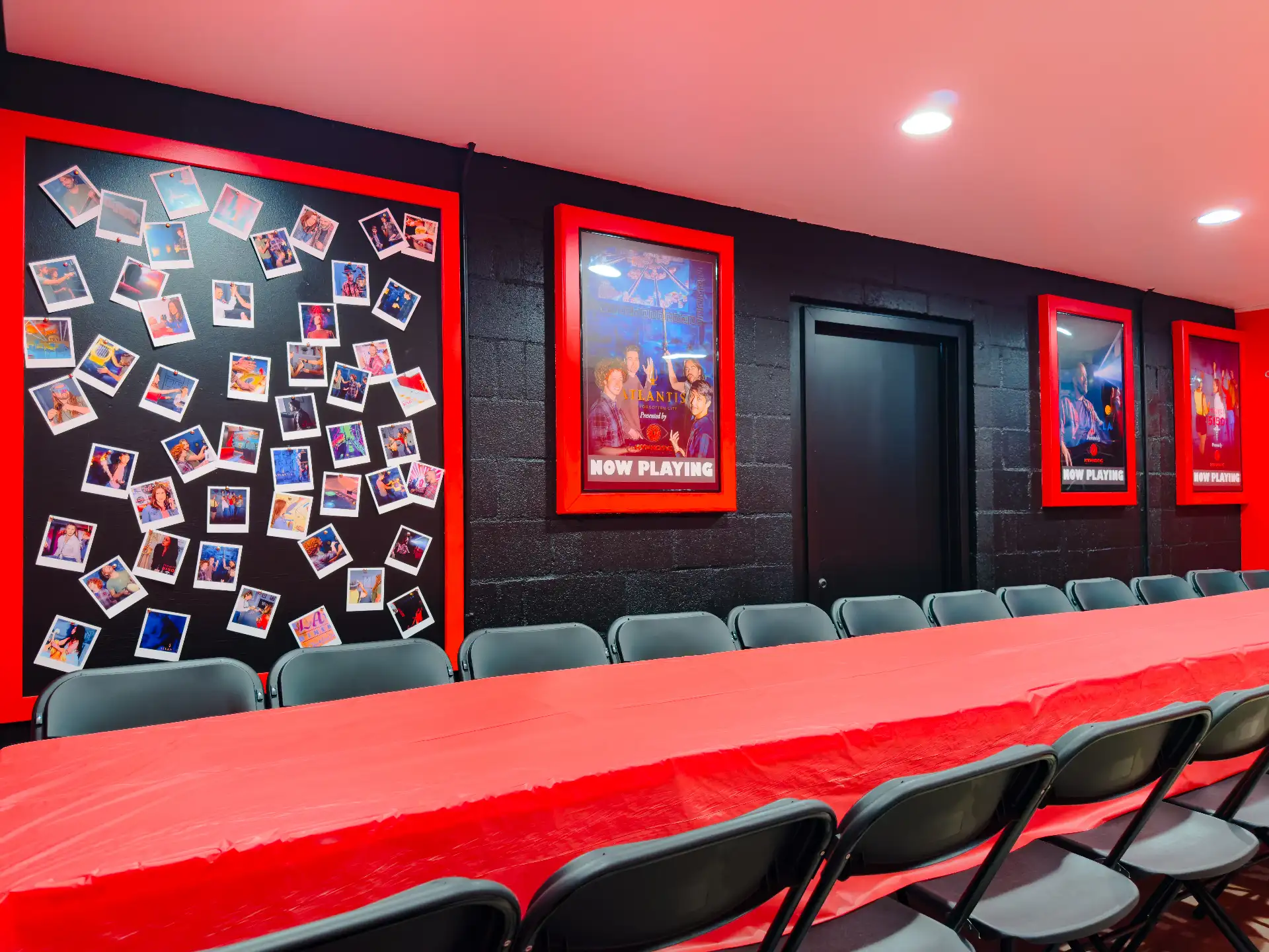 The party room seen from the doorway — polaroid wall, framed game posters, and the full table set with chairs