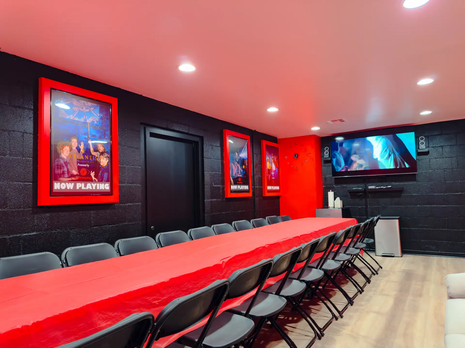 The banquet table set for a group, with the wall screen and framed game posters behind it